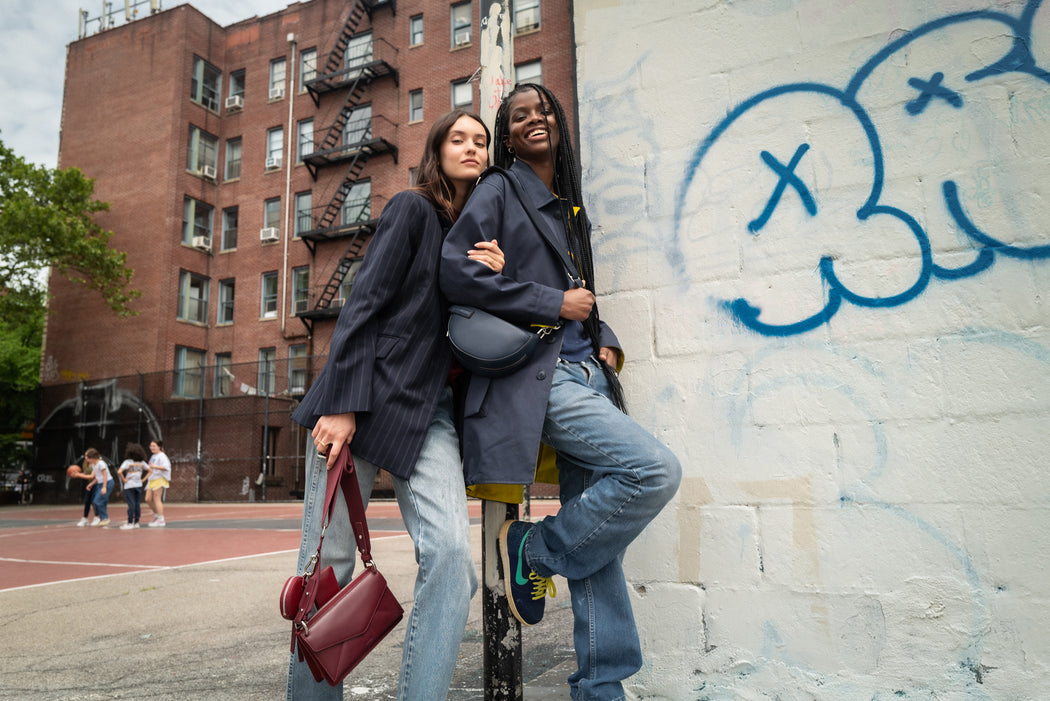 Two WE-AR4 models standing by wall at outdoor basketball court in NYC