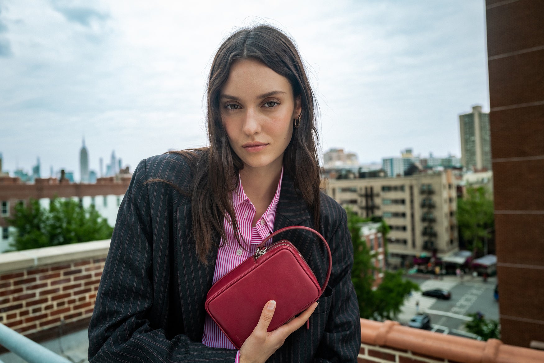 WE-AR4 model on rooftop in New York holding maroon handbag